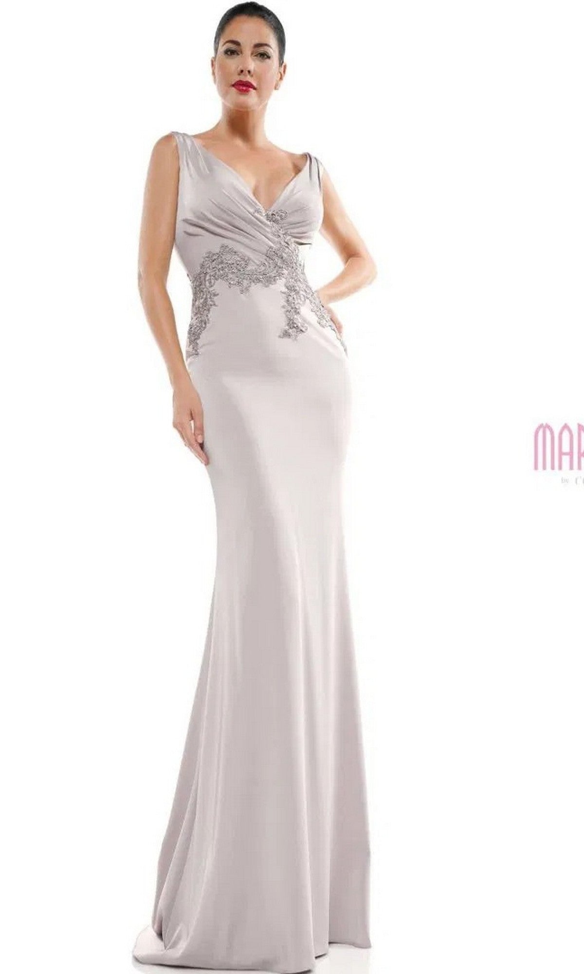 A woman in the Marsoni MV1054 long formal dress, silver color, featuring a sleeveless design, deep V-neckline, and intricately embroidered bodice, stands against a plain white background.